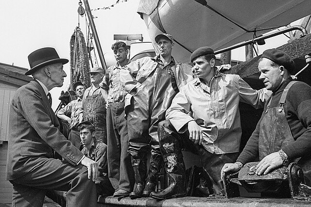 Rt. Hon. Vincent Massey discussing with fishermen. St. John’s, Newfoundland. Image via Wikimedia Commons.